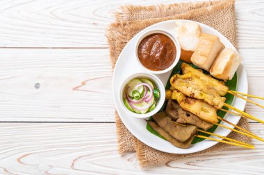 Pork Satay ve Ciğer Satay. Ekmek, fıstık sosu ve turşu. Salatalık dilimleri ve soğan sirkeli.