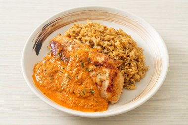 Kırmızı köri soslu ızgara tavuk bifteği ve pilav. Müslüman usulü.