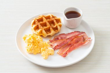 Kahvaltı için çırpılmış yumurta, pastırma ve waffle.