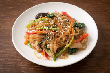 Japchae ya da karışık Kore vermicelli erişte sebzeli ve üzerine beyaz susamlı domuz eti - Kore geleneksel yemek tarzı