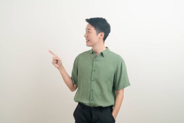 Beyaz arka planda eli işaret eden ya da sunan genç Asyalı adam portresi