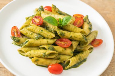 Pesto soslu ve domatesli makarna. Vejetaryen ve vejetaryen yemek tarzı.