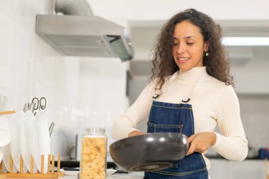 Güzel Latin kadın mutfakta yemek yapıyor.