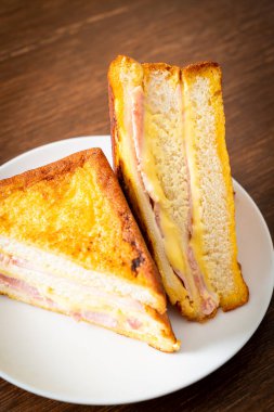 Beyaz tabakta ev yapımı jambonlu peynir.