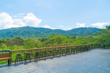 Balkonda boş bir bank ve bar taburesi var.