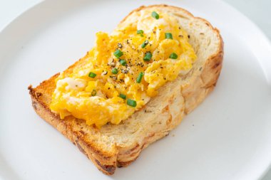 Ekmek tostu, çırpılmış yumurta ve beyaz tabak.