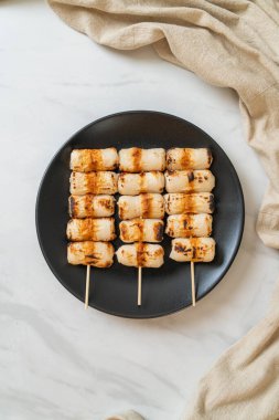 Izgara tüp şeklinde balık ezmeli kek ya da tabakta mürekkep balığı şişi.