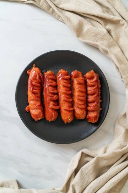 Siyah tabakta kızarmış sosis şişi.