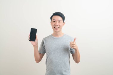 Beyaz arka planda akıllı telefon ve cep telefonu kullanan ya da konuşan genç Asyalı adam