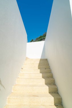Beyaz duvar ve mavi gökyüzü ile merdiven basamağı