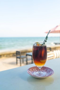 Okyanus arkaplanlı buzlu americano kahve şeftalisi.