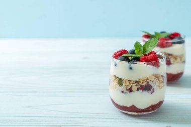 Ev yapımı ahududu ve yaban mersinli yoğurt ve granola. Sağlıklı yemek tarzı.