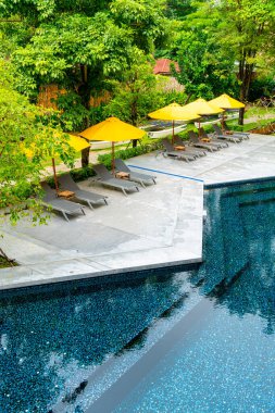 Otelin havuzunda havuz çevresinde şemsiye ve bilardo takımı.