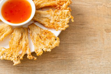 Kızarmış enoki mantarı ya da baharatlı soslu altın iğneli mantar - vejetaryen yemek tarzı.