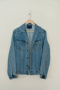 jacket jean hanging with wood hanger on wall