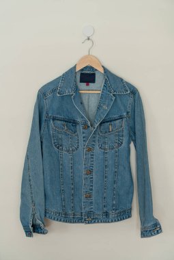 jacket jean hanging with wood hanger on wall