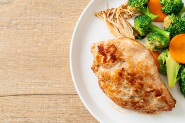 Beyaz tabakta sebzeli ızgara tavuk bifteği