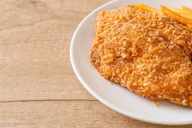 Kızarmış tavuk göğsü fileto biftek yanında patates kızartması ve ketçap.