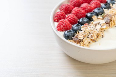 Ev yapımı yoğurt kasesi, ahududu, yaban mersini ve granola. Sağlıklı yemek tarzı.