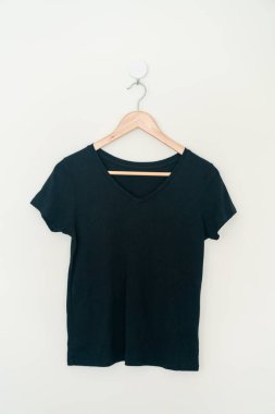 woman t-shirt hanging with wood hanger on wall