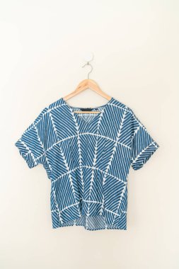 tie dye shirt hanging with wood hanger on wall