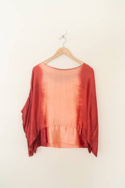 tie dye shirt hanging with wood hanger on wall