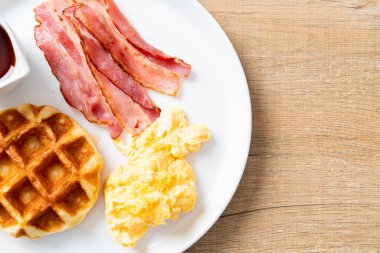 Kahvaltı için çırpılmış yumurta, pastırma ve waffle.