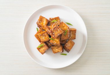 Beyaz susamlı kızarmış tofu ve teriyaki sosu. Vejetaryen ve vejetaryen yemek tarzı.
