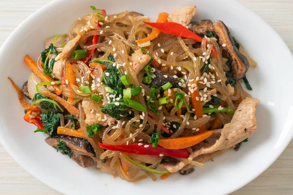 Japchae ya da karışık Kore vermicelli erişte sebzeli ve üzerine beyaz susamlı domuz eti - Kore geleneksel yemek tarzı