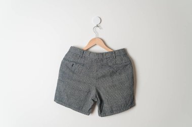 Kısa pantolon duvarda ahşap bir askıyla asılı.