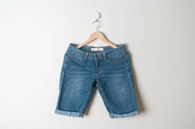 Duvarında ahşap askılı kısa pantolon.