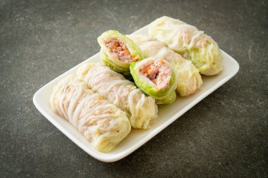 Çin lahanasına sarılı ev yapımı kıymalı domuz eti ya da haşlanmış lahana.