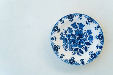 Beyaz masanın üzerinde güzel bir porselen tabak.