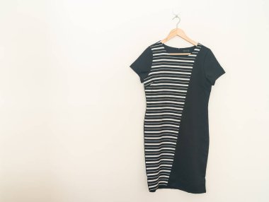 beautiful black dress hanging with wood hanger on wall