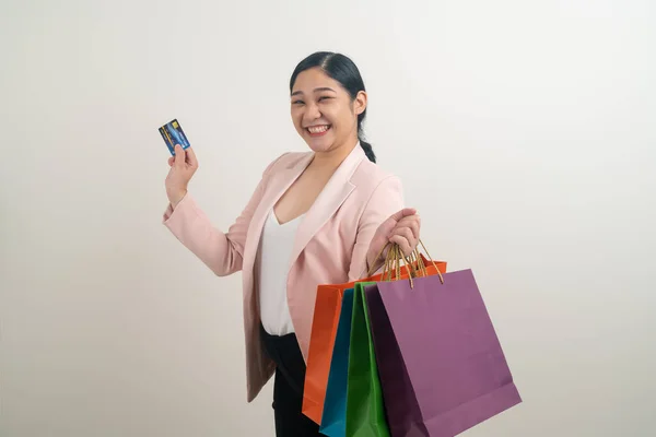白い背景を持つ手にショッピングバッグやクレジットカードを持つアジアの女性 — ストック写真