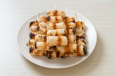 Izgara tüp şeklinde balık ezmeli kek ya da tabakta mürekkep balığı şişi.