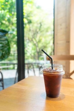 Kafe restoranının masasında kahve bardağında buzlu Americano kahvesi.
