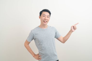 Beyaz arka planda eli işaret eden ya da sunan genç Asyalı adam portresi