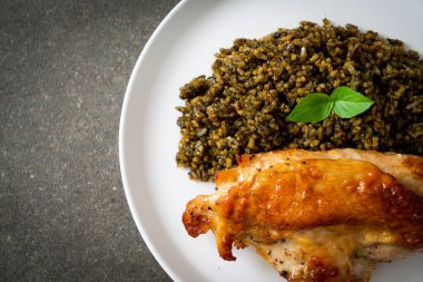 Kızarmış pesto pilavı ve beyaz tabakta kızarmış tavuk.
