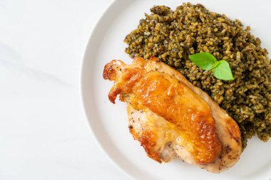 Kızarmış pesto pilavı ve beyaz tabakta kızarmış tavuk.