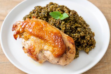 Kızarmış pesto pilavı ve beyaz tabakta kızarmış tavuk.