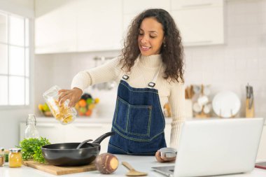 Latin kadın blogda paylaşmak için mutfakta video ve yemek çekiyor.