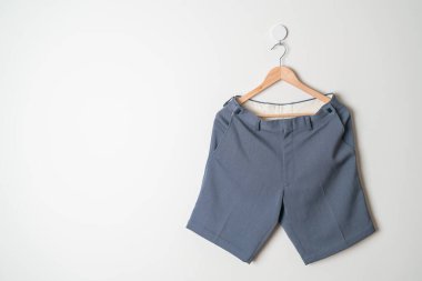 Kısa pantolon duvarda ahşap bir askıyla asılı.