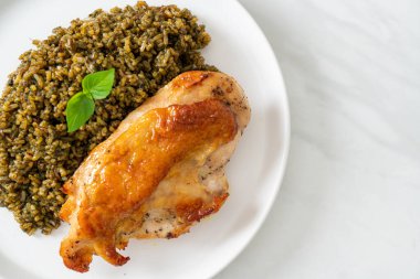 Kızarmış pesto pilavı ve beyaz tabakta kızarmış tavuk.