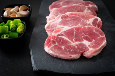 Taze domuz boyunlu ya da yakalı domuz eti ve terbiye edilecek malzemeler.