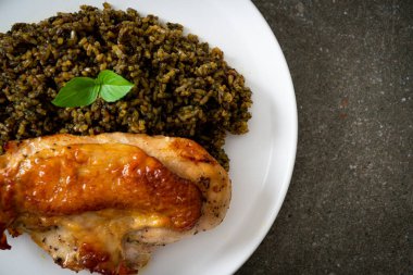 Kızarmış pesto pilavı ve beyaz tabakta kızarmış tavuk.