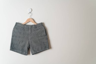Kısa pantolon duvarda ahşap bir askıyla asılı.