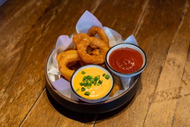 Ketçaplı soğan halkası ve tabakta sos.