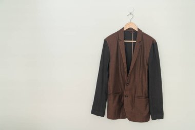 dark brown suit hanging with wood hanger on wall