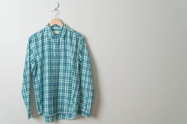 duvarında ahşap askı olan çizgili tişört